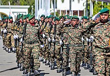 Photograph of a group of men in military uniforms marching in close formation