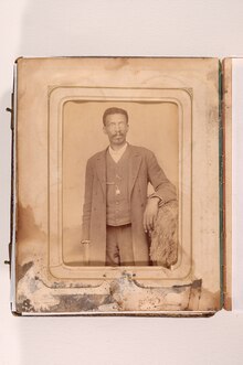 An image of a scrapbook page with a black and white photo of William Thornton Montgomery on it. William is an an African American man of slender build and short curly hair. He has a full moustache and goatee, is wearing a three piece suit and glasses.