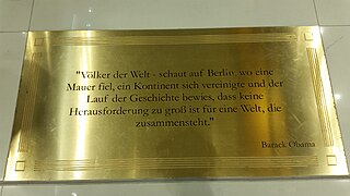 One of several brass plaques in front of the escalators with quotes from prominent people (here from Barack Obama)