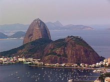 Brown mountain surrounded by water.