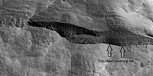 HiWish计划下高分辨率成像科学设备所显示的洼地近景，箭头指示的地方有一层极薄，据信是1-2米厚的水冰覆盖层。
