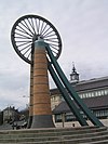 Large wheel on brick tower.