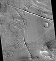 火星侦察轨道器的 HiRISE 拍摄科勒槽沟内的岩脉或断层，这两种地形都可能会造成矿物沉积。