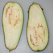 Longitudinal section of eggplant. There are almost no seeds at the top but they become plentiful at the bottom. Although the photograph was taken just a few moments after slicing, the flesh of the eggplant has already begun to oxidize