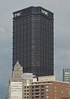 a black tower with a triangular floor plan. You can see two of the sides with the acronym "UPMC" sits at the top of each side.