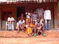 Basankusu - a family in front of a fired-brick house with palm-leaf roof and concrete floor.