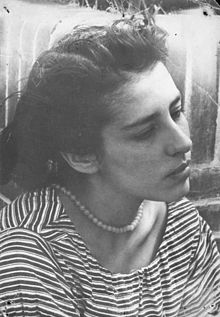 B&W portrait photo of a young woman wearing a striped shirt and pearls, her hair swept back from her face.