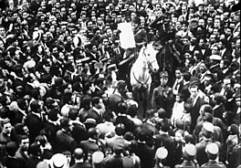 People surround a messenger on a horse who is announcing the new government of primo de rivera
