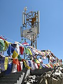 FE13. A cell phone tower in Leh, Ladakh, altitude 11,500 feet, surrounded by Buddhist prayer flags. India's telecommunication network is the third largest in the world in customer base. Enabled by hyper-competition in its market, it has one of the lowest tariffs.