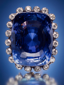 Large blue sapphire surrounded by twenty diamonds