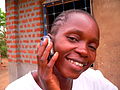 A Basankusu woman celebrates being connected to the outside world by mobile phone with a phone call to relatives in Kinshasa.