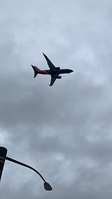 Plane pictured as it passes over Downtown [[San Jose]] and [[Highway 87]].