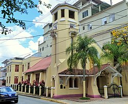 Photograph of a modest church with a prominent tower in an urban setting