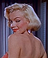 Marilyn, sleek peroxide, side parted with a bang. 1953