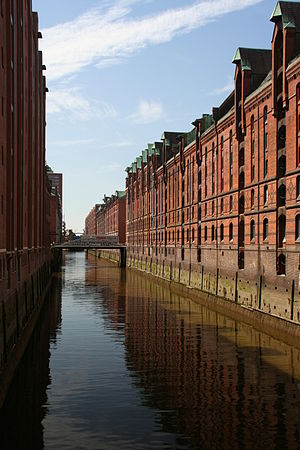 a row of multi-storey red brick houses at a water body.