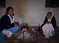 Indian schoolgirls in their uniforms making tea over an open fire.