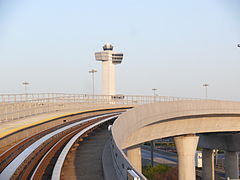 JFK Airport's control tower in the background and an AirTrain guideway in the foreground