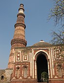 D-25. The Qutb Minar (background) with the Alai Darwaza (foreground), built around 1200 CE, in what is now New Delhi, are enduring symbols of the Delhi Sultanate. The complex is a UNESCO World Heritage Site.