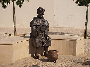 一个坐在石台上的铜人，面前放着一口铁罐来煮石头汤。