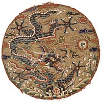 Roundel with dragon design. China, Qing-dynasty, late 17th century. Peacock feather barbules are used to highlight the dragon's scales.