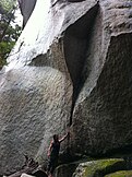 Climber standing at the distinctive 'Cobra' silhouette groove at the start of the Cobra Crack