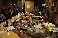 Activity at a robatayaki. Seafood and vegetables to cook displayed
