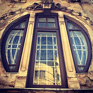 Mix of Art Nouveau and Egyptian Revival – Round corner window of the Romulus Porescu House (Strada Doctor Paleologu no. 12) in Bucharest, decorated with lotus flowers, a motif used frequently in Ancient Egyptian art, designed by Dimitrie Maimarolu (1905)[177]