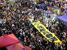 Hong Kong protesters holding a banner reading "I want real universal suffrage."