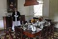 Dining table; the wooden fan from the ceiling was attached to a rope and powered by servants for cooling the room.