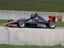 a small open wheeled race car with large aerodynamic wings