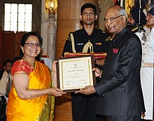 Woman on left awarded prize by Indian President on right