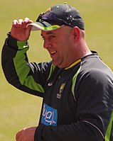 Picture of Lehmann wearing an Australian training jersey and holding a cap