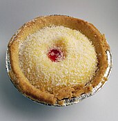 The Manchester tart is a traditional English baked tart consisting of a shortcrust pastry shell, spread with raspberry jam, covered with a custard filling and topped with flakes of coconut and a Maraschino cherry.