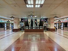 The upper platform with escalators leading to the lower or concourse level of the station