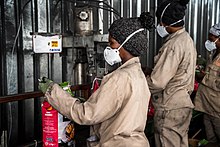 workers packing charcoal in paper bags