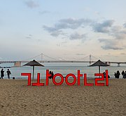 A sculpture of the beach's name and bridge in background (2020)