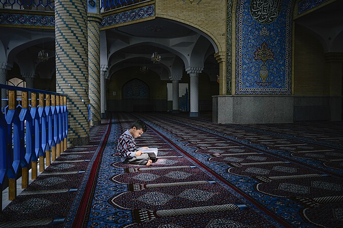 圖為伊朗庫爾德斯坦省薩南達季達爾哈桑清真寺（英語：Dar ul-Ihsan Mosque）內，一名正在閱讀書籍的男孩。