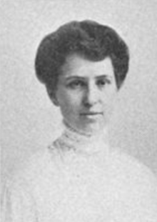 A young white woman with dark hair, wearing white