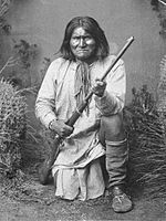 Geronimo (Goyaałé), a Bedonkohe Apache; kneeling with rifle, 1887