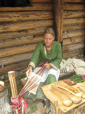 Rigid heddle made of cane, in a single-heddle loom weaving a narrow work band; replica of the European Dark Ages.