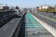 半地下部地上侧（名古屋市名东区）。后来噪音等级被判定超过国家标准，因此在开口部进行加盖工程[19]。两侧为国道302号。
