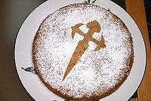 Photo of a cake with the image of a Saint James cross in powedered suger