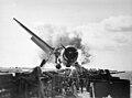 Image 37Crash landing of an F6F Hellcat into the port side 20mm gun gallery of the USS Enterprise, November 10, 1943. Lieutenant Walter L. Chewning, Jr., USNR, the Catapult Officer, is climbing up the plane's side to assist the pilot from the burning aircraft. The pilot, Ensign Byron M. Johnson, escaped without significant injury. Note the plane's ruptured belly fuel tank.