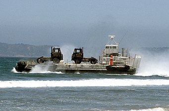 A US Army LACV-30 (Lighter Air Cushion Vehicle - 30 Ton) hovercraft transporting ground-support military equipment to the shore in 1986.