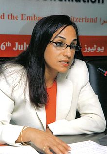 a picture of Amina Bouayach, seated behind a microphone