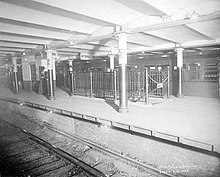 Black-and-white image of the Bowling Green station platform, with a track in the foreground