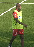 A man wearing a red shirt and red shorts covered with a light green bib.