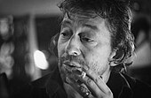 A black and white shot of Serge Gainsbourg, peering to the left of a nearby camera.