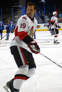 Man wearing hockey equipment skating on rink