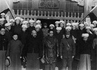 1934年，宋子文、馬步芳在青海西寧的清真寺前，與當地男性回族民眾合影。回族男性穿着長袍馬褂的同時，以佩戴白色纏頭的方式，展示穆斯林身份。